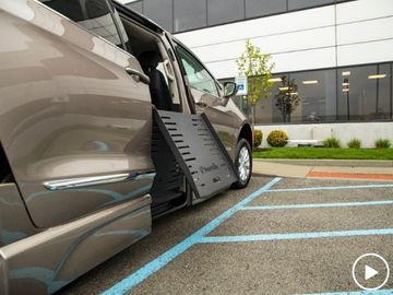 Fold-out wheelchair ramp deploying from a side-entry BraunAbility Chrysler Pacifica parked in a disability parking spot