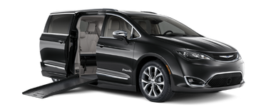 Wheelchair accessible Chrysler Pacifica with BraunAbility power fold-out ramp deployed, exterior front and passenger-side view