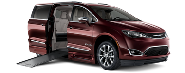 Wheelchair accessible Chrysler Pacifica with BraunAbility power in-floor ramp deployed, exterior front and passenger-side view