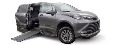 Wheelchair accessible Toyota Sienna handicap van with BraunAbility power in-floor ramp. Exterior view of front and passenger side of vehicle with wheelchair ramp deployed.