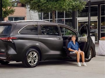 Woman entering Toyota Sienna minivan with turn out seat