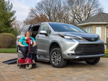 Woman on mobility scooter in front of wheelchair accessible Toyota Sienna with ramp deployed
