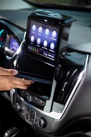 Touchscreen lifted to reveal hidden storage in a BraunAbility Chevrolet Traverse wheelchair accessible SUV