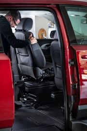 Person removing driver seat from a BraunAbility Chevrolet Traverse wheelchair accessible SUV