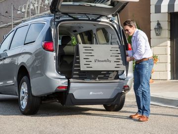 Man deploys manual fold-out wheelchair ramp from the rear of a BraunAbility Chrysler Pacifica wheelchair van