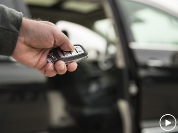 Hand holding Chrysler Pacifica key fob to demonstrate integration with wheelchair ramp operation
