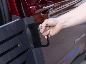 Person's hand demonstrating use of the easy-grip handle to deploy the ramp on the BraunAbility CompanionVan wheelchair van 