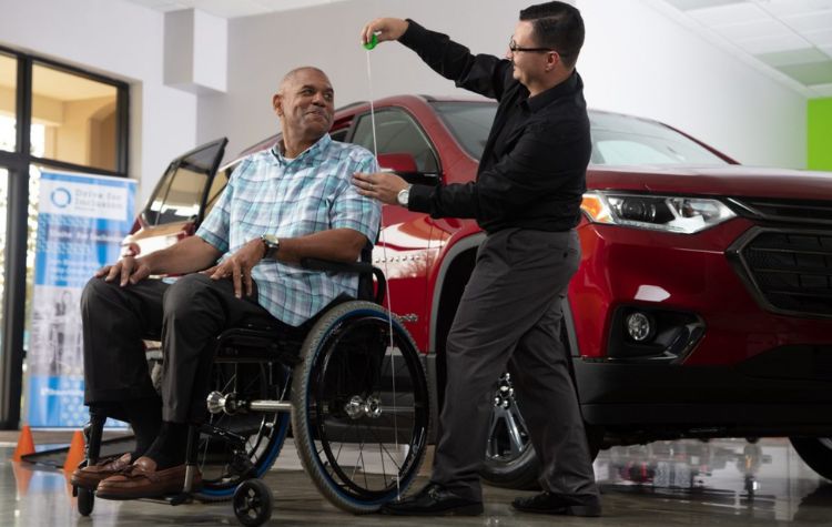 A mobility consultant measures height of a customer in dealership showroom 