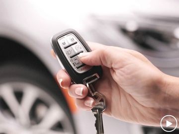 Hand holding Chrysler Pacifica key fob to demonstrate integration with VMI Northstar wheelchair ramp