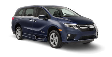 Wheelchair accessible Honda Odyssey handicap van with BraunAbility power fold-out ramp. Exterior view of front and passenger side of vehicle with wheelchair ramp stowed and doors closed.