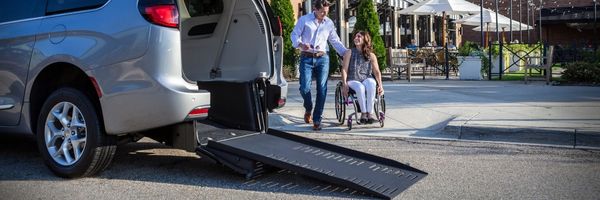 Two people leaving a resturant and entering a rear-entry wheelchair accessible van