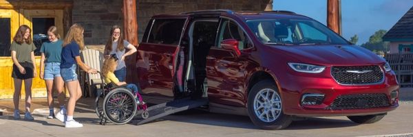 Group of people entering a wheelchair accessible van with the ramp deployed