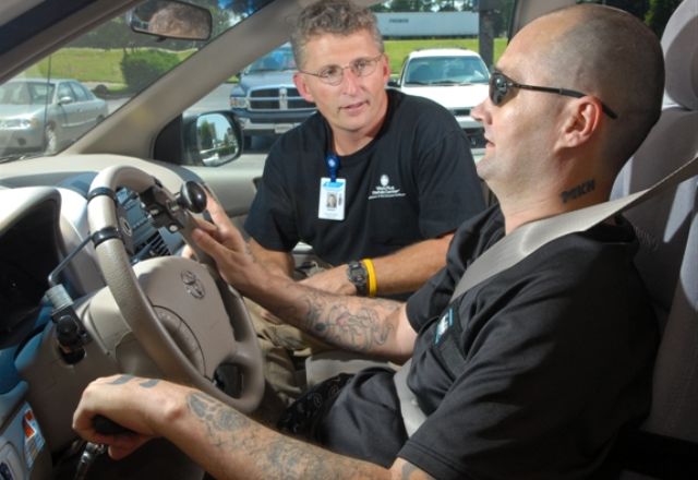Driver rehabilitation specialist in vehicle with client driving with hand controls