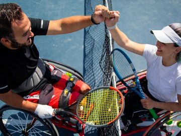 Wheelchair tennis players greeting each other at the net
