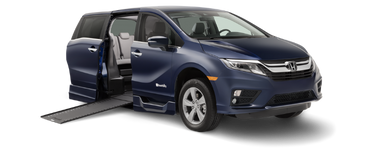 Exterior front and passenger-side view of a BraunAbility Honda Odyssey wheelchair van with ramp deployed