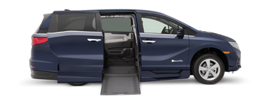 Passenger-side exterior view of a BraunAbility Honda Odyssey wheelchair van with ramp deployed