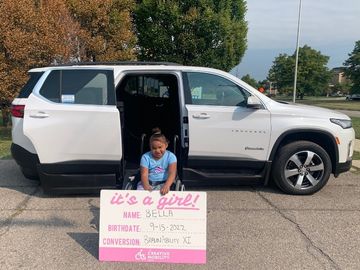 Child in front of a wheelchair accessible Chevy Traverse