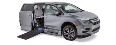 Exterior front and passenger-side view of a VMI Northstar Honda Odyssey wheelchair van with ramp deployed