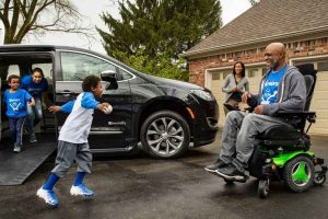 Family wearing baseball shirts exit a wheelchair accessible Chrysler Pacifica minivan