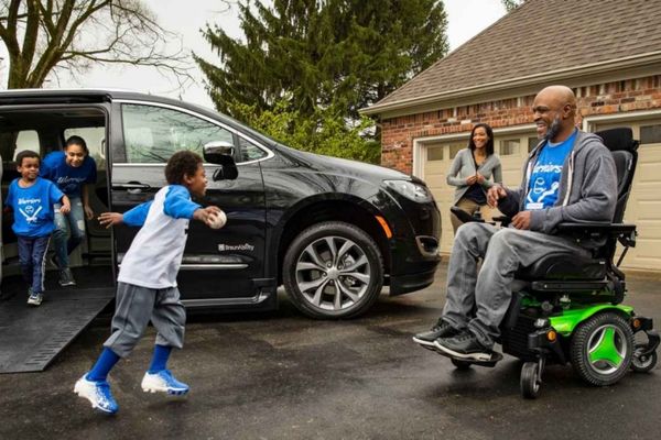 Family wearing baseball shirts exit a wheelchair accessible Chrysler Pacifica minivan
