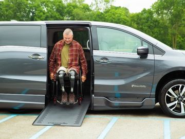 Man with bilateral lower limb loss exiting a BraunAbility wheelchair accessible Honda Odyssey