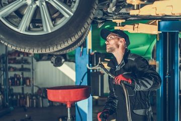 Auto technician changing the oil on a wheelchair accessible van