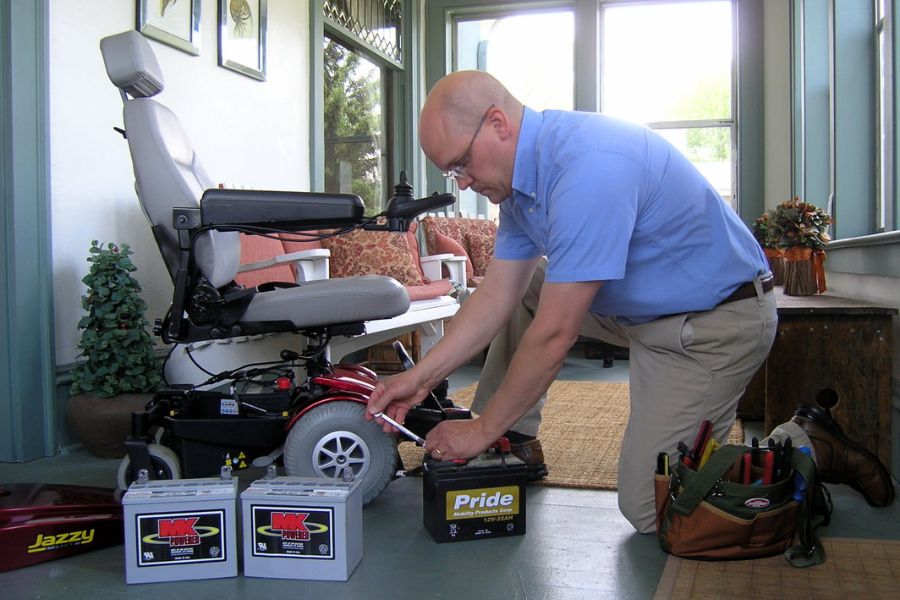 Service technicians replaces batteries on a Pride Jazzy power wheelchair