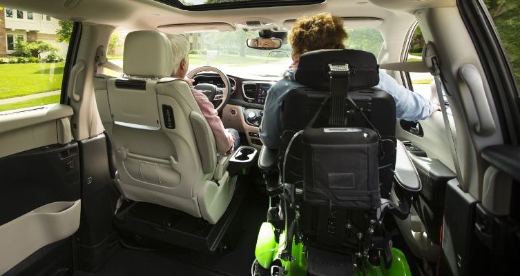 Man driving wheelchair accessible van with female passenger seated in a power wheelchair.