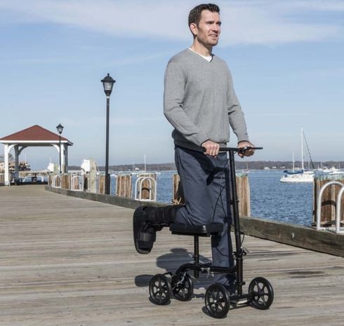 Man using a knee scooter on a dock