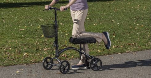 Woman using a knee walker in a park
