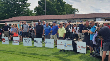 Group of golfers standing along the green at the Lori's Voice Golf Outing