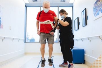Healthcare worker assisting patient to walk