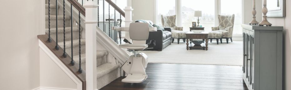 Bruno Elan stair lift parked at the bottom of a staircase.