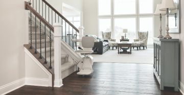 Stair lift chair docked at bottom of staircase
