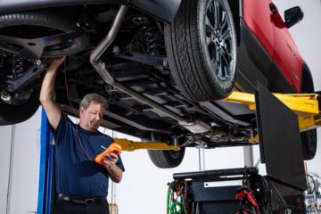 Technician servicing a wheelchair accessible vehicle, representing professional repair and maintenance of mobility equipment
