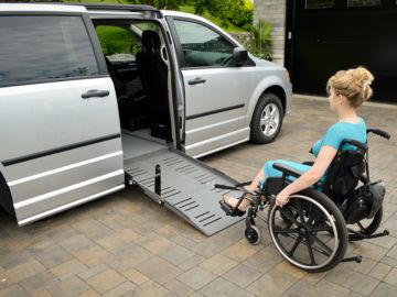 Adapt Solutions Power-Pull assisting a manual wheelchair user up a lowered floor van ramp